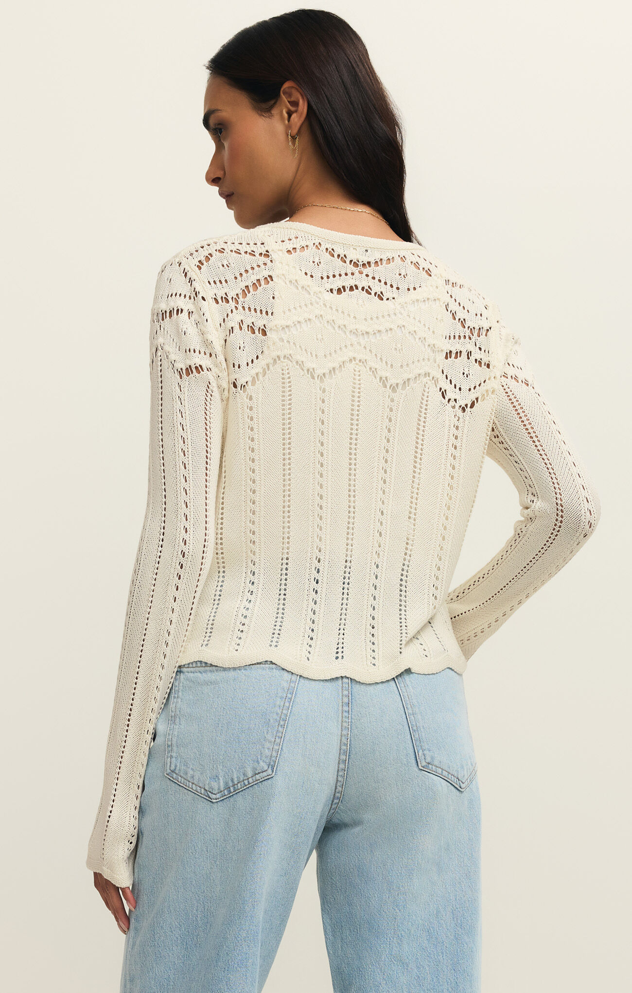 Back view of a woman wearing the Cloud Alycia Crochet Sweater by z supply with intricate delicate crochet patterns