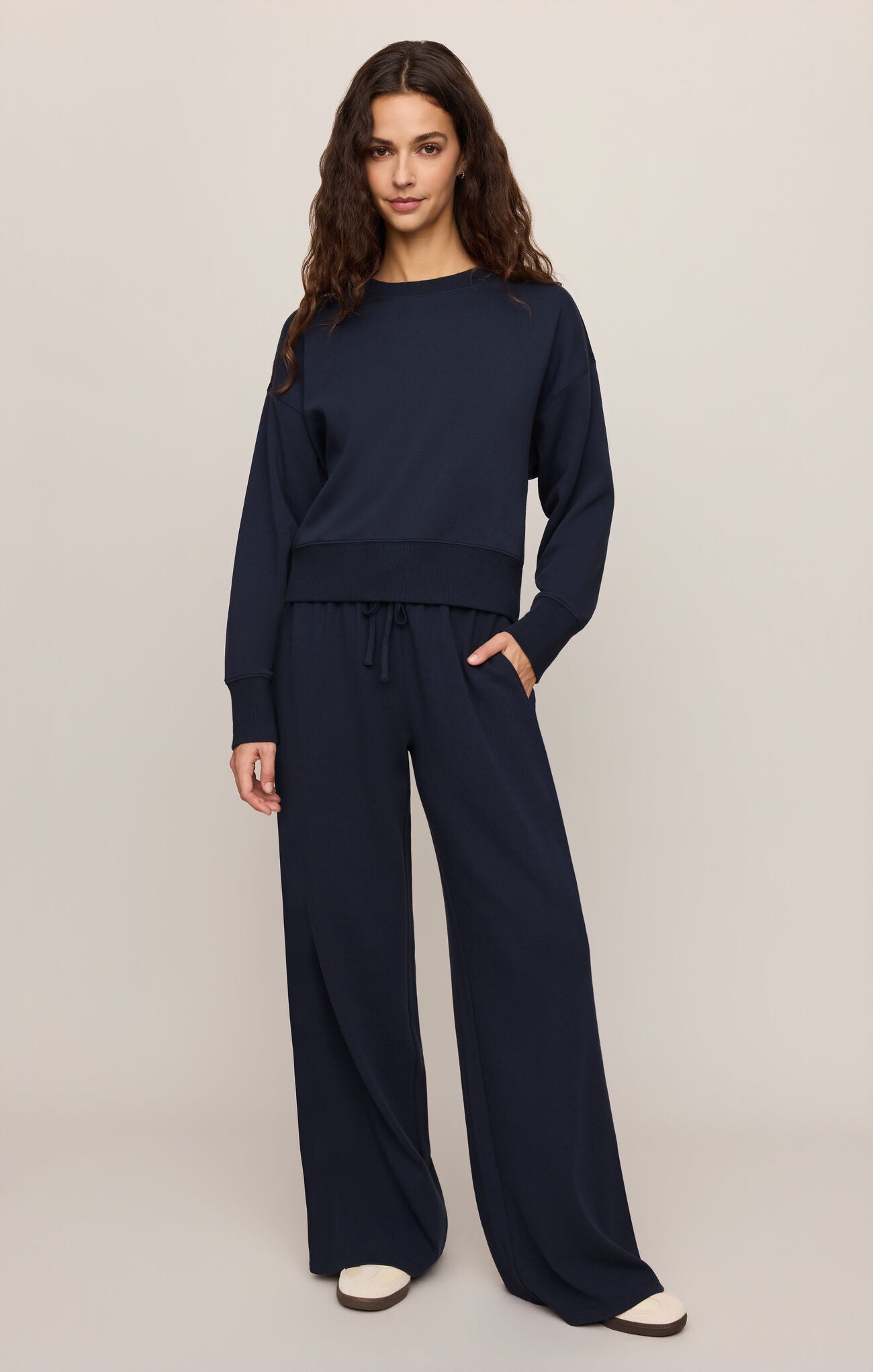 Woman wearing navy Eclipse Comеback Sweatshirt by z supply paired with matching wide-leg pants and white shoes