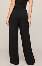 Back view of a woman wearing Black In Transit Modal Pant by z supply, featuring a relaxed fit and soft fabric.