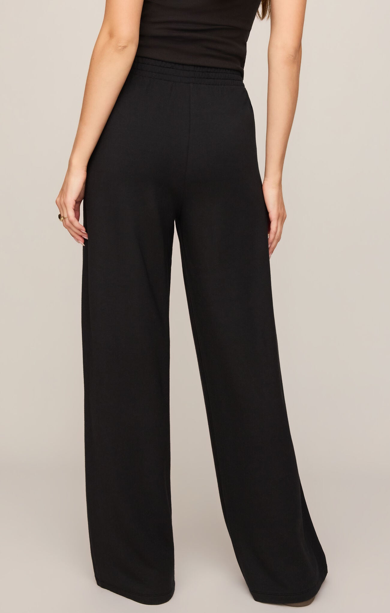 Back view of a woman wearing Black In Transit Modal Pant by z supply, featuring a relaxed fit and soft fabric.