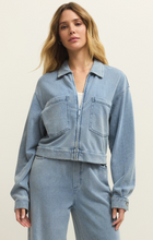 Model wearing Ocean Air Indigo Heritage Knit Denim Jacket by z supply in soft blue knit fabric with front pockets and collar design