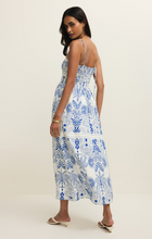 Woman wearing Nautical Nadine Palm Maxi Dress by z supply with blue tropical and nautical prints and thin straps