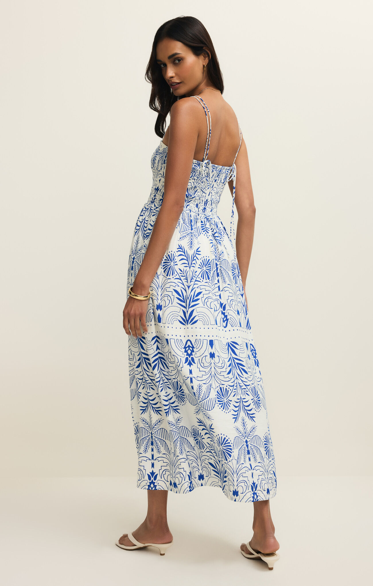 Woman wearing Nautical Nadine Palm Maxi Dress by z supply with blue tropical and nautical prints and thin straps