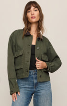 Woman wearing a Dusk Sage Rey Cropped Chore Jacket from z supply with large front pockets and button closure