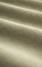 Close-up view of soft knit brushed fleece fabric in bay leaf green color showing texture and weave details