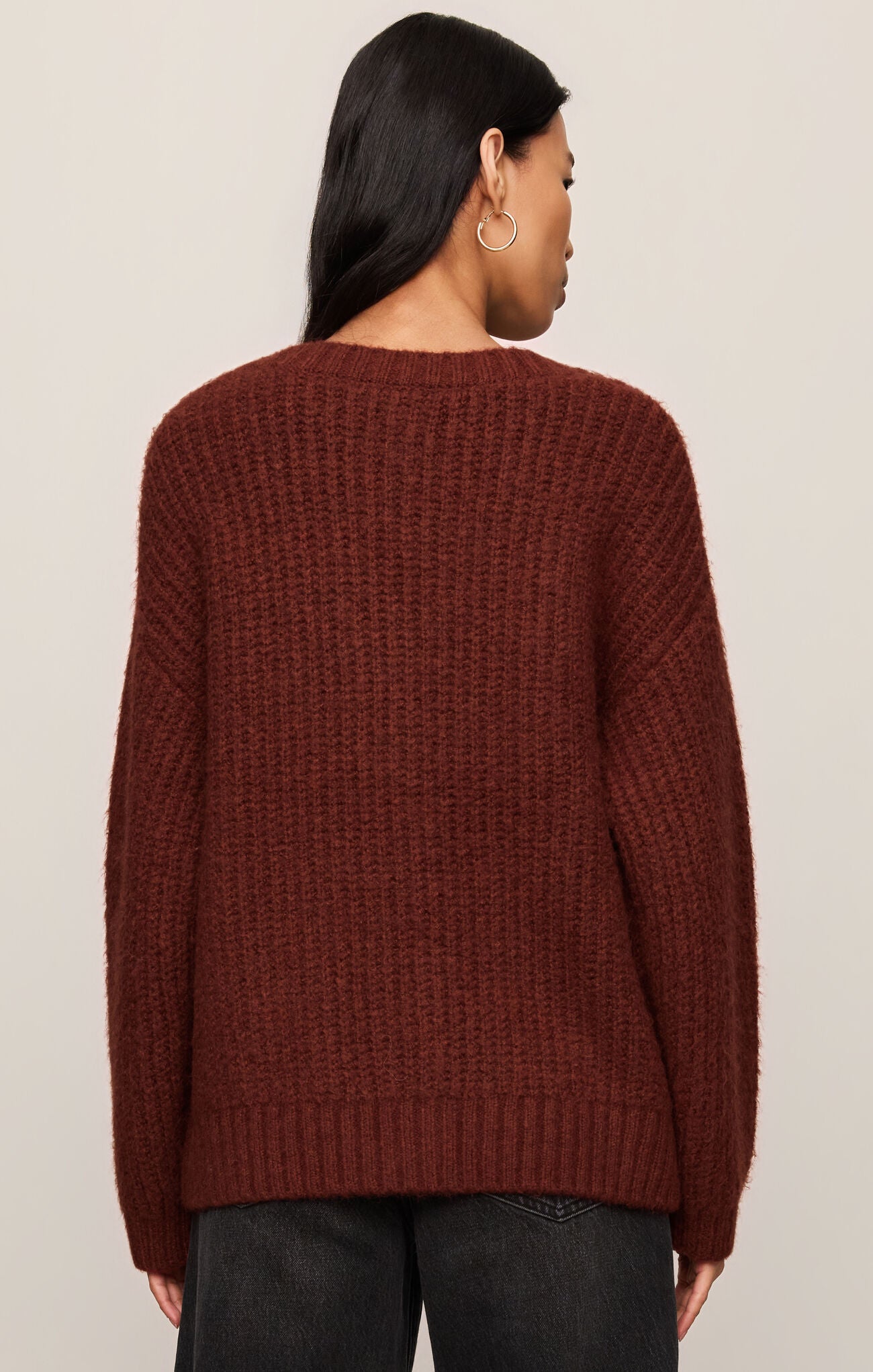 Woman wearing a deep red knit Velvet Rouge Whitmore Cardigan by z supply, shown from the back with black jeans