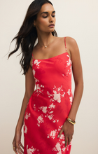 Woman wearing Kiss Me Red Alyse Darya Floral Maxi Dress by z supply with white floral pattern and thin straps