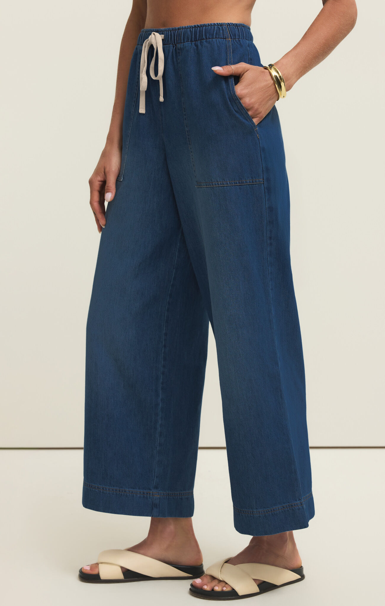 Side view of z supply Deep Water Daycation Denim Utility Pant with elastic waist and wide leg silhouette