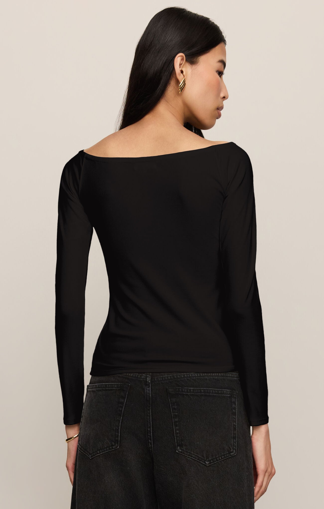 Woman wearing a long sleeve Black Sabrina Top by z supply, shown from the back with a wide neckline and fitted silhouette.