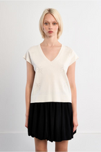 Woman wearing Molly Bracken White Palm Top with short sleeves and subtle palm motifs paired with a black skirt