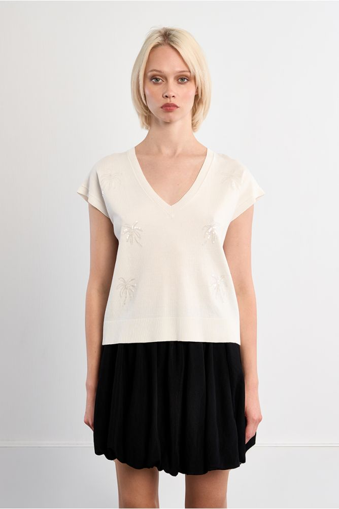 Woman wearing Molly Bracken White Palm Top with short sleeves and subtle palm motifs paired with a black skirt