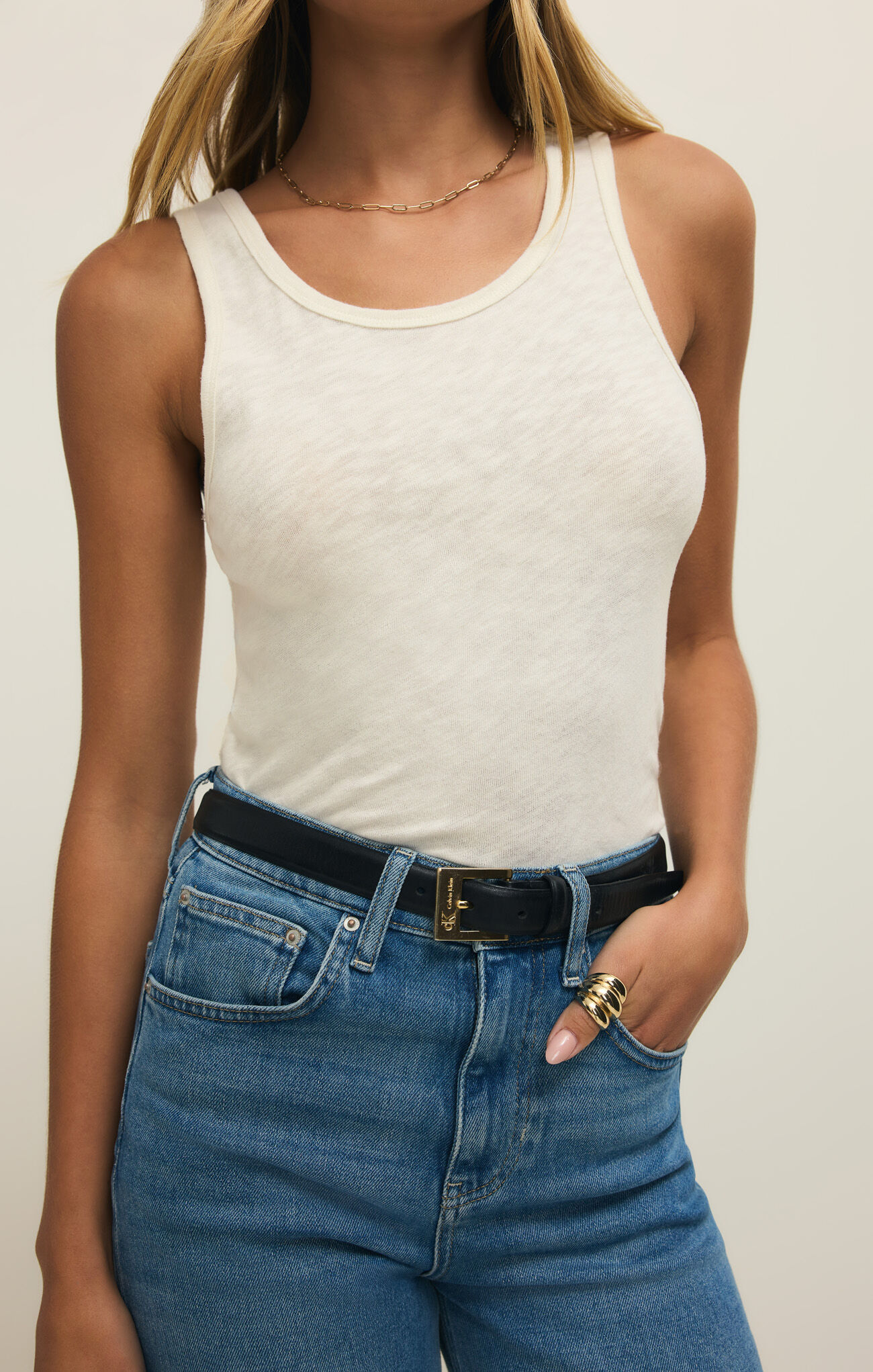 Woman wearing Cloud Classic Slub Scoop Tank by z supply in soft fabric paired with high-waist jeans and black belt