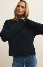Woman wearing a navy Eclipse Bellami Sweater by z supply with textured knit and relaxed fit paired with blue jeans