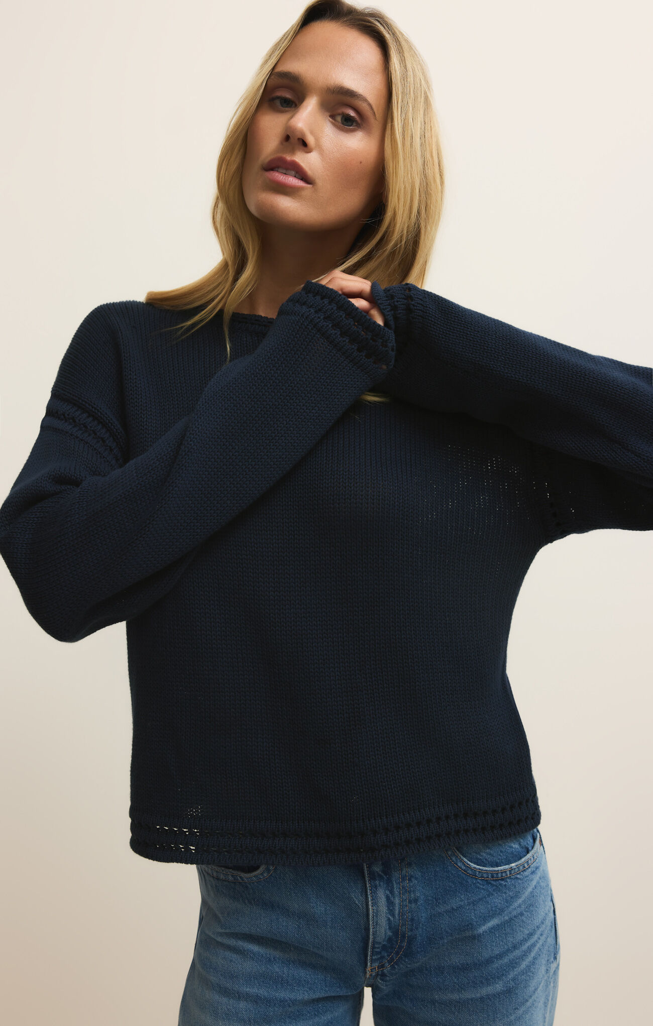 Woman wearing a navy Eclipse Bellami Sweater by z supply with textured knit and relaxed fit paired with blue jeans