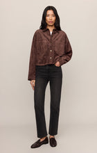 Model wearing a dark chocolate all day cropped suede jacket by z supply with black jeans and loafers.