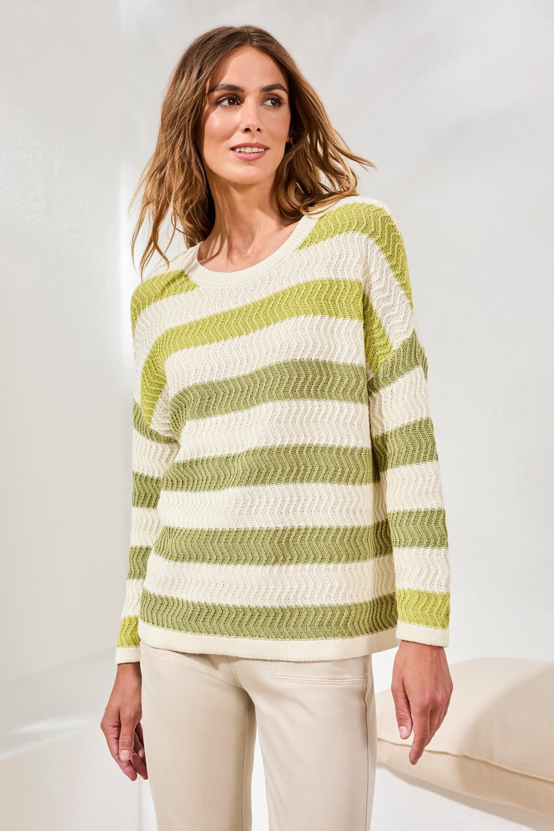 Woman wearing Tribal Kiwizest Crew Neck Drop Shoulder Sweater in green and cream stripes with beige pants