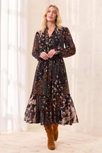 Tribal Mixed Print Drama Dress in black floral mixed print with long sleeves and tiered hem modeled with brown boots
