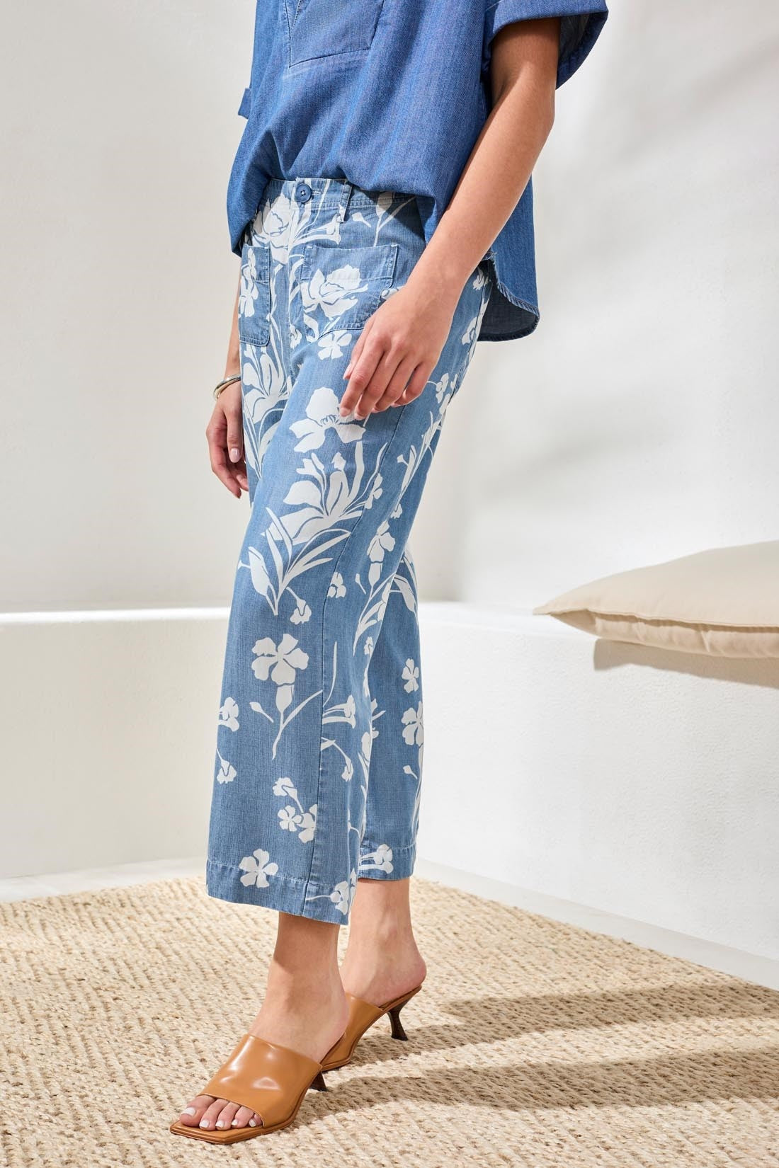 Side view of woman wearing Tribal Denim Printed Wide Leg Crop Pant in blue with white floral design and tan heels
