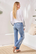 Rear view of woman wearing Tribal Embroidered Sophia Curvy Flare jeans with floral embroidery by Tribal in light wash denim