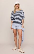 Woman wearing a relaxed striped top and matching shorts holding a sweater, wearing Eclipse The Everyday Striped Crew by z supply