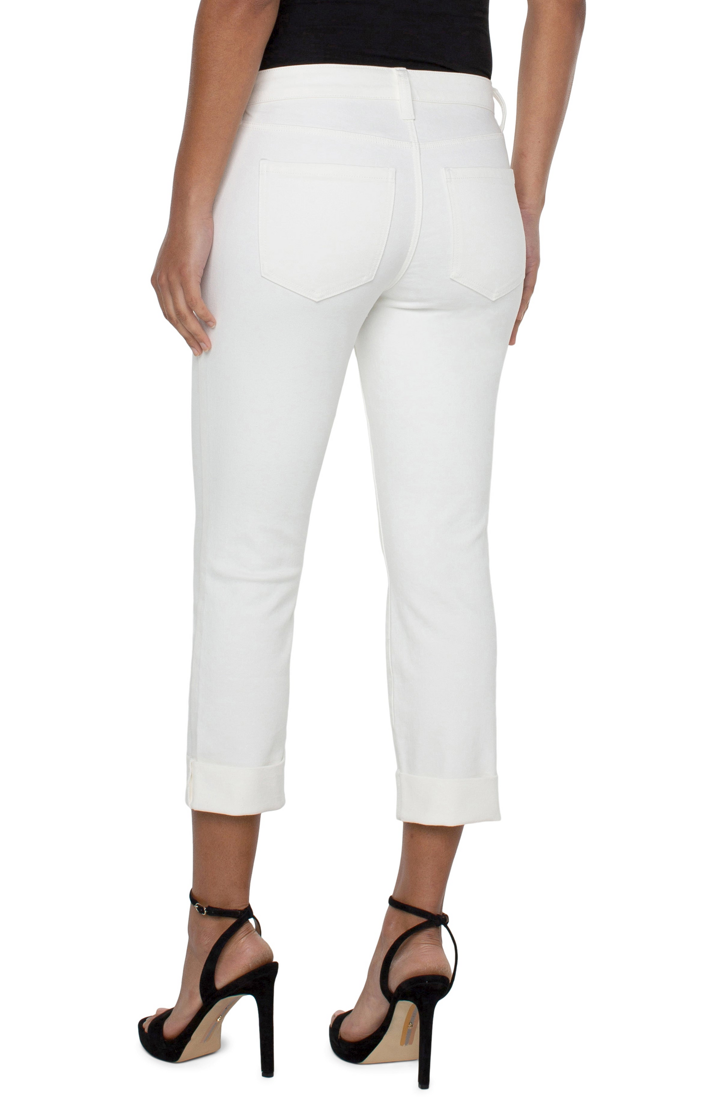 Rear view of a person wearing Bone White Charlie Crop Wide Rolled Cuff 24inch Inseam pants by liverpool with black heels