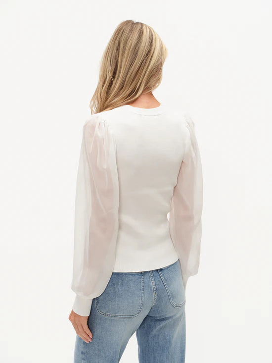 Woman wearing White Celeste Mixed Media Top by six/fifty with sheer puff sleeves and fitted waist, paired with jeans back view