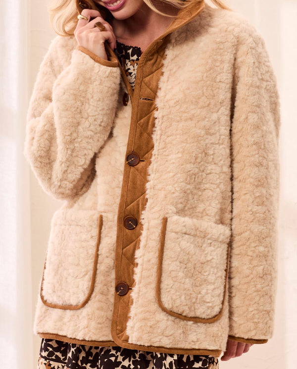 Tribal Walnut Reversible Coat in cream sherpa with walnut brown trim worn with a patterned skirt