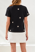 Back view of a woman wearing Tribal Embroidered Daisy Short Sleeve Crew Neck Top with white daisy embroidery and white skirt