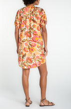 Back view of a woman wearing a tan floral short sleeve shirred button front woven dress by liverpool