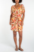 Woman wearing tan floral short sleeve shirred button front woven dress by liverpool with a waist tie and sandals
