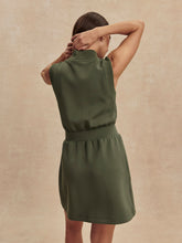 Woman seen from behind wearing an olive green Thyme Polyanna Half Zip Dress by Varley with sleeveless design and high collar.
