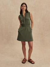 Woman wearing olive green sleeveless Thyme Polyanna Half Zip Dress by Varley with zip front and side pockets