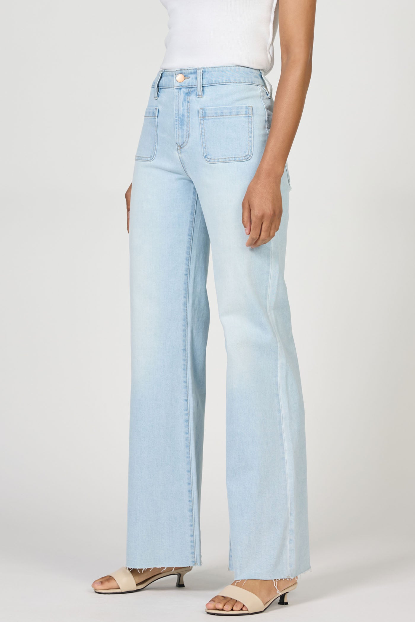 Light wash Misty Cloud Micah Jeans by dear john with a relaxed fit styled with beige sandals and white top