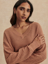 Woman wearing a camel Camel Gaia V Neck Sweater by Varley with textured knit and ribbed cuffs against neutral background