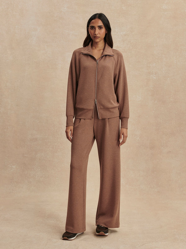 Model wearing Varley-Golden Bronze Marl Tyde Zip Through Sweat in warm bronze tone with relaxed pants and sneakers