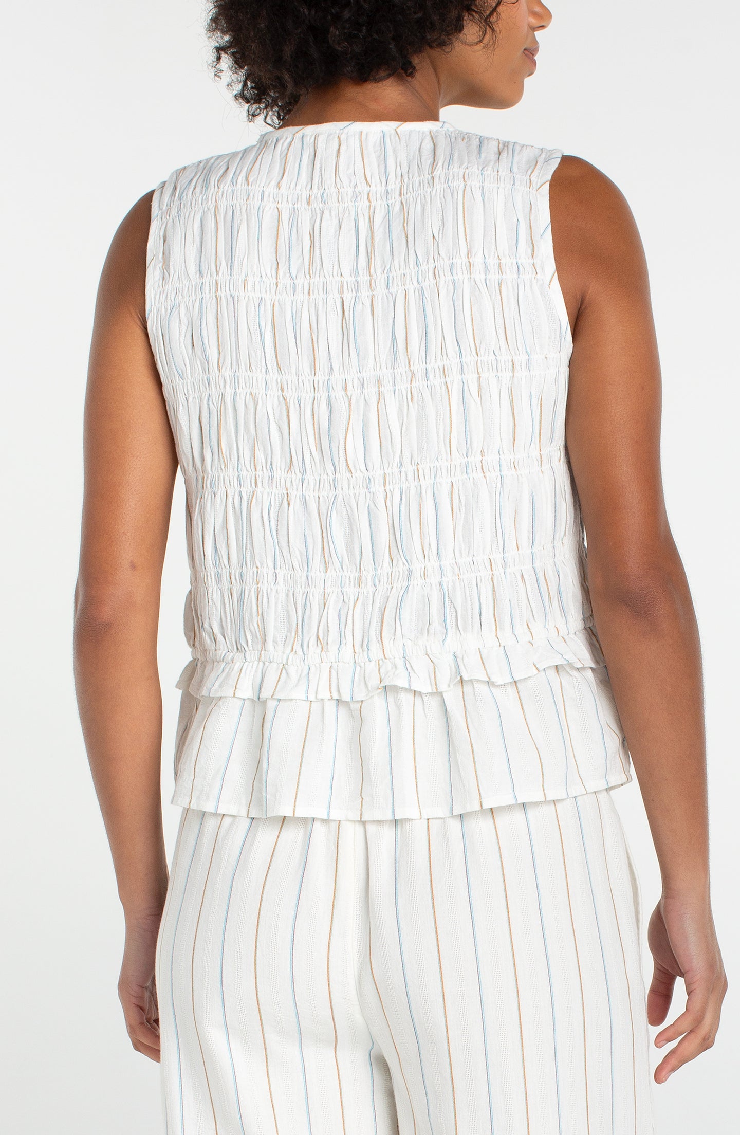 Back view of a woman wearing Cream/Blue Multi Stripe Sleeveless Tie Front Woven top by liverpool with matching striped pants.