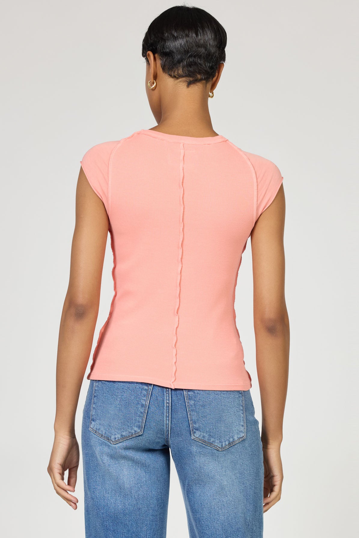 Back view of a model wearing the brand dear john Terracotta Kiyomi Top paired with blue jeans in a studio setting