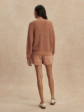 Woman wearing camel-colored Camel Gaia V Neck Sweater by Varley, shown from the back with matching shorts.