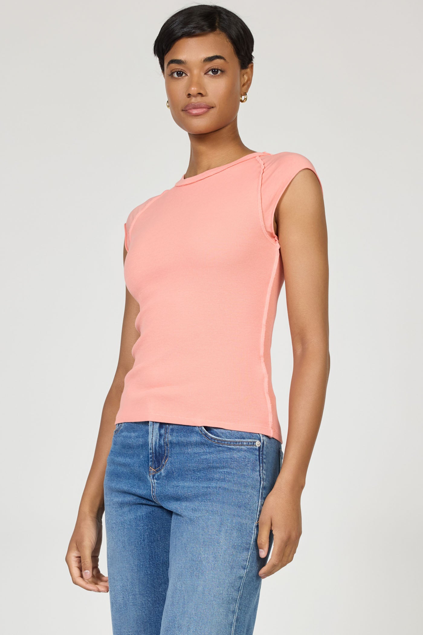 Model wearing a sleeveless terracotta Kiyomi Top by dear john, styled with casual blue jeans on a white background