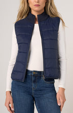Woman wearing a Heather Navy Reversible Zip Front Quilted Sweater Vest by liverpool over white top and blue jeans
