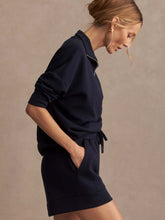 Woman wearing Navy Atrium High Rise Short 4.5 by Varley paired with matching navy long-sleeve top