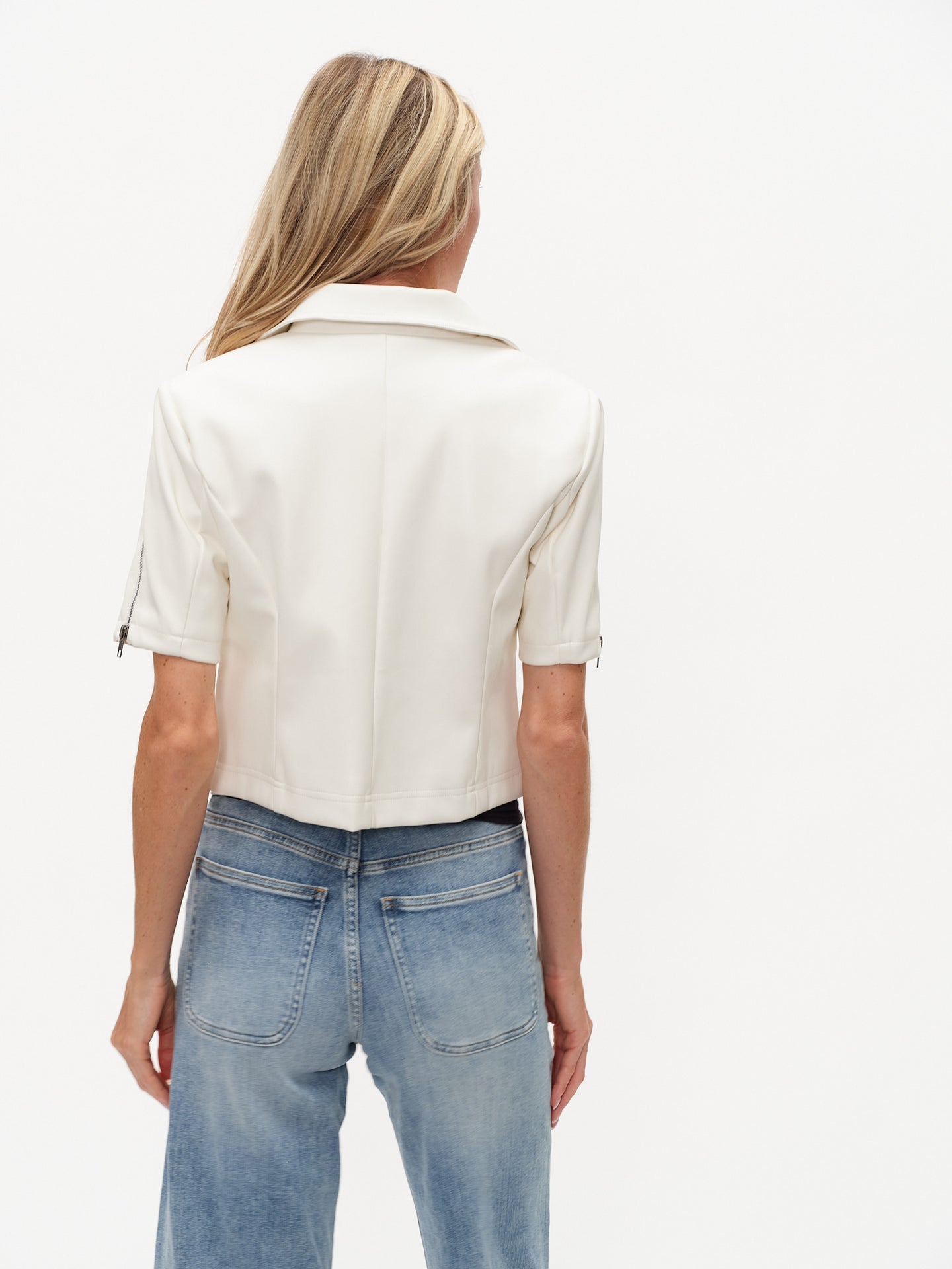Back view of a model wearing the White Monroe Faux Leather SS Collared Jacket by six/fifty with short sleeves and crisp white finish