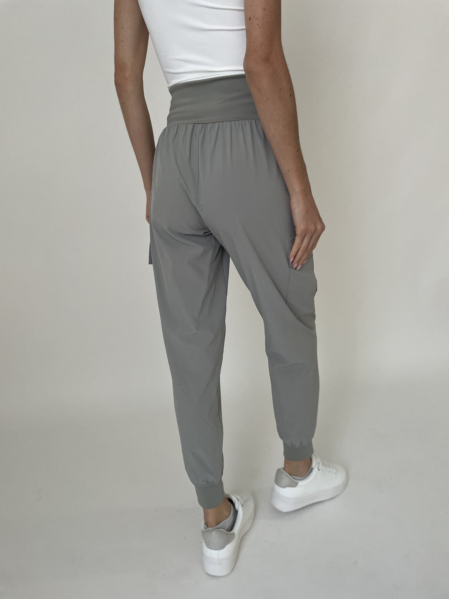 Rear view of Taupe Kristie Lightweight Jogger by six/fifty on model wearing white sneakers and a white tank top