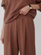Close-up of Varley Golden Bronze Marl The Extra Wide Leg Pant -29.5 worn with matching top and watch detail on wrist