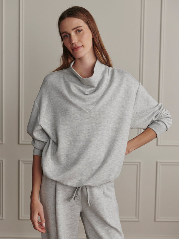 Varley Light Grey Marl Betsy Sweat worn by a woman in a neutral interior