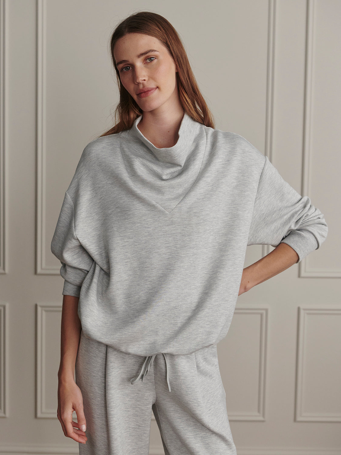Varley Light Grey Marl Betsy Sweat worn by a woman in a neutral interior