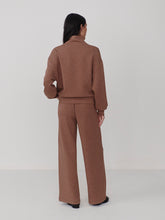 Woman wearing Varley Golden Bronze Marl The Extra Wide Leg Pant -29.5 in brown from the back, paired with a matching top.