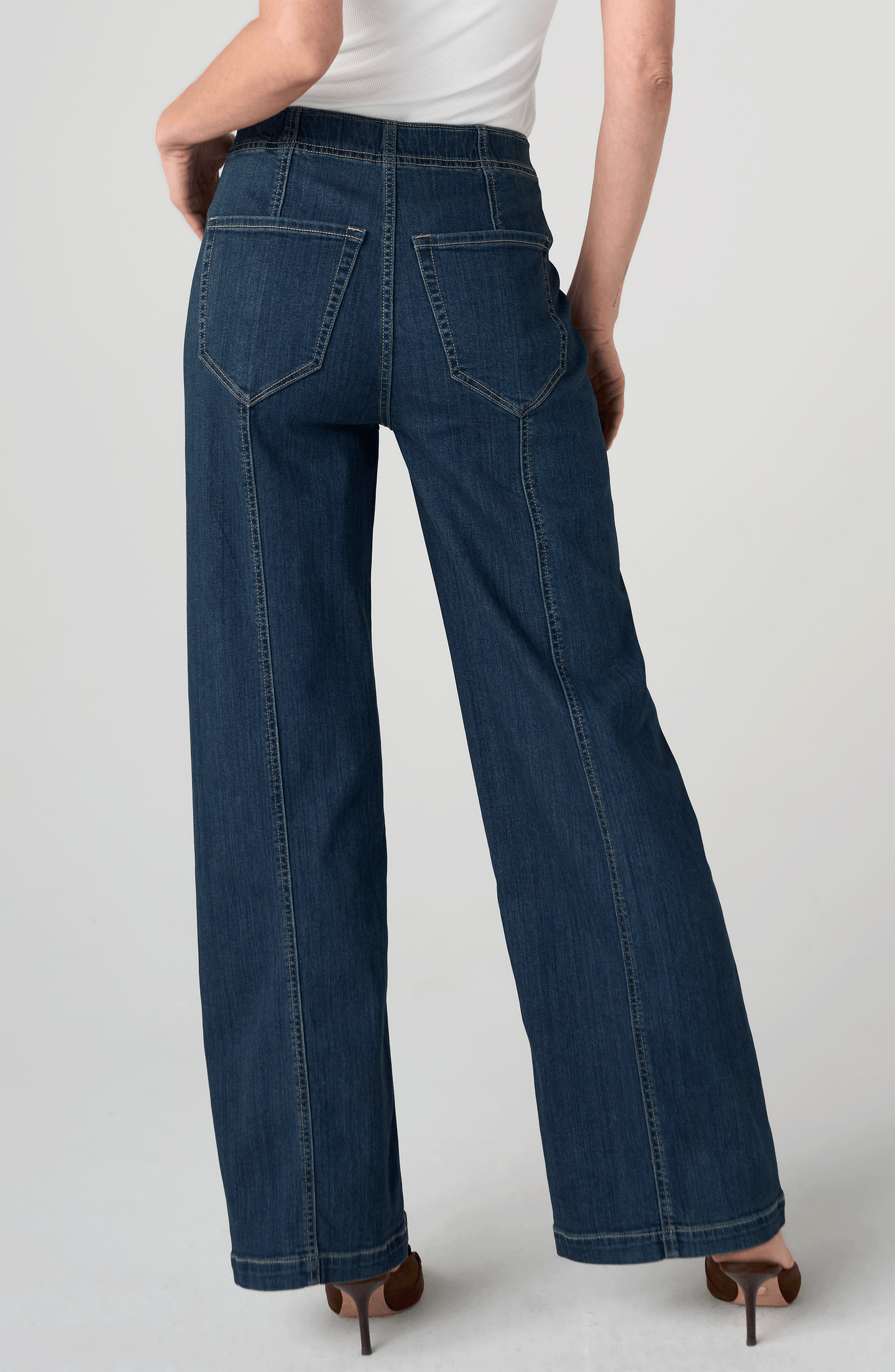 Woman wearing Crosswind High Rise Pull-On Wide Leg with Seam Detail 32" Ins by liverpool in dark denim from the back