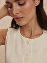 Close-up of a woman wearing Varley Prinstine Josie Button Through Tank in creamy white with large buttons down front