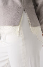Close-up of soft grey heather V neck long sleeve sweater with lace detail layered over white pants by liverpool